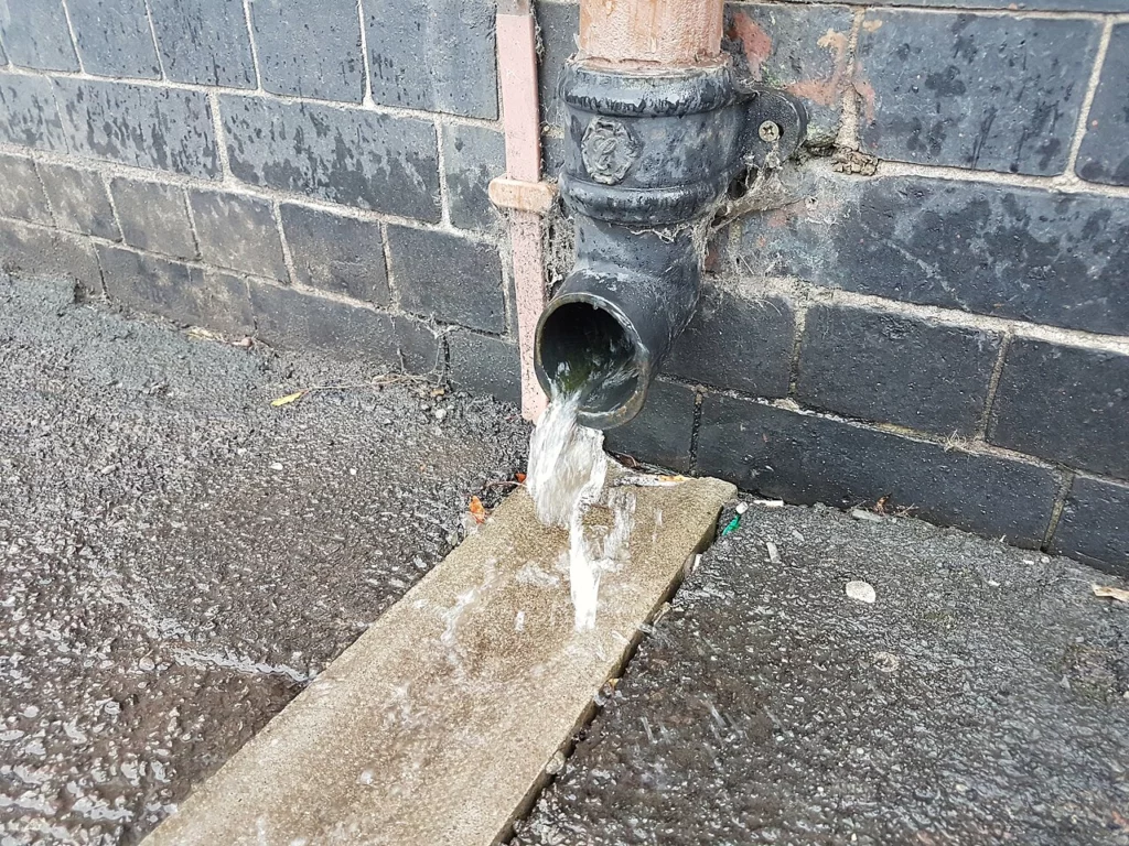Водосточная труба с отводом дождевой воды в сторону от септика на участке